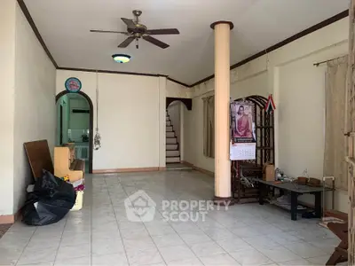 Spacious living room with ceiling fan and tiled floor in a cozy home