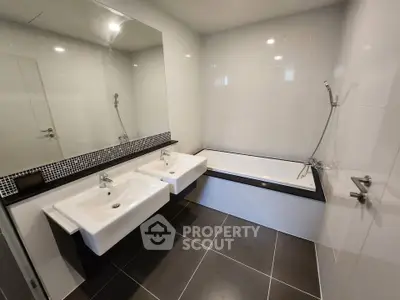 Modern bathroom with dual sinks and bathtub in sleek design