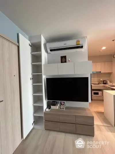 Modern living room with sleek TV unit and open kitchen layout