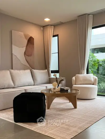 Modern living room with stylish furniture and large windows offering natural light.