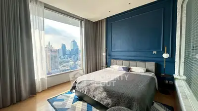Luxurious bedroom with stunning city view and elegant blue accent wall