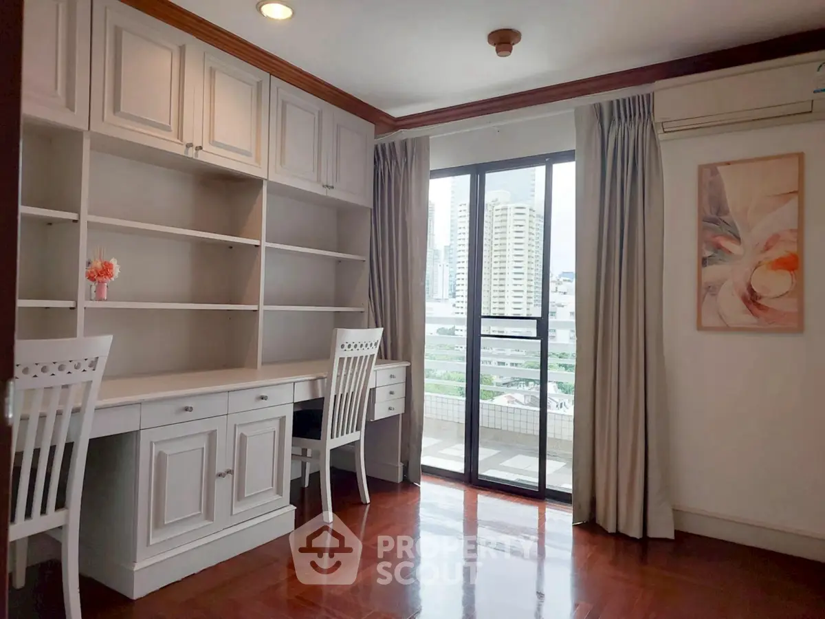 Elegant study room with built-in shelves and city view balcony access