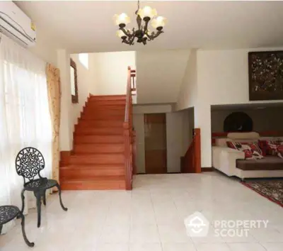 Elegant living room with staircase and chandelier in modern home