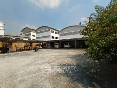 Spacious parking area in front of modern residential building with clear sky view.