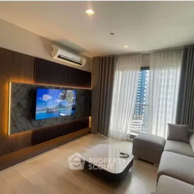 Modern living room with sleek design, featuring a wall-mounted TV and large window with city view.