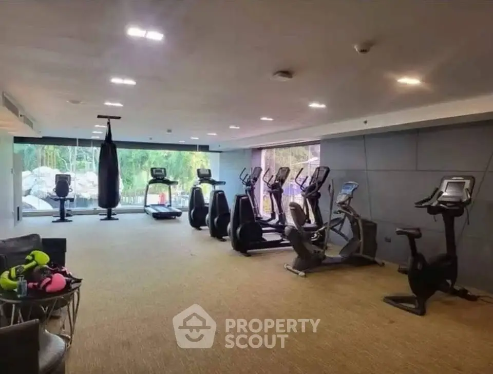 Modern gym with exercise equipment and large windows in luxury real estate property.
