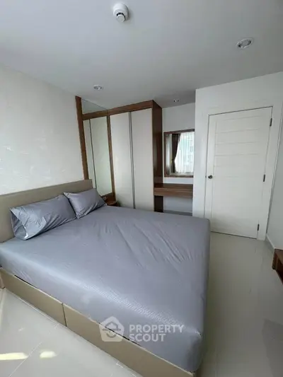 Modern bedroom with sleek design and ample storage in a contemporary apartment.