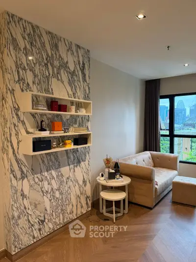 Stylish living room with marble accent wall and city view, featuring cozy beige sofa and modern decor.