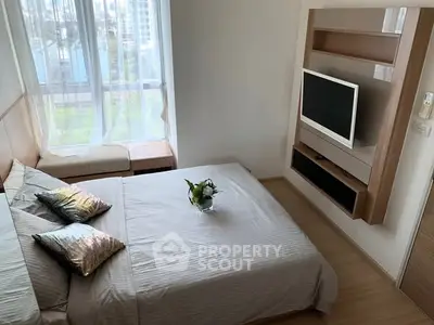 Modern bedroom with large window and wall-mounted TV in a stylish apartment.
