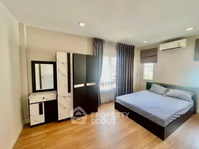 Spacious bedroom with modern furniture and natural light, perfect for comfortable living.