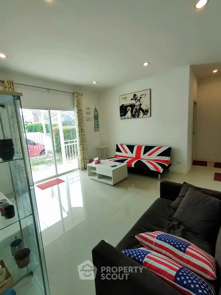 Bright living room with modern decor and large sliding glass doors opening to garden view.
