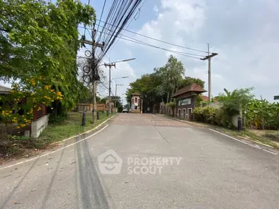 Charming gated community entrance with lush greenery and clear skies.