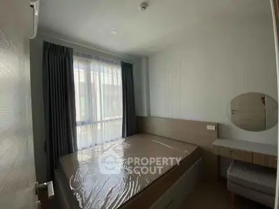 Cozy bedroom with natural light and modern furnishings, perfect for relaxation.