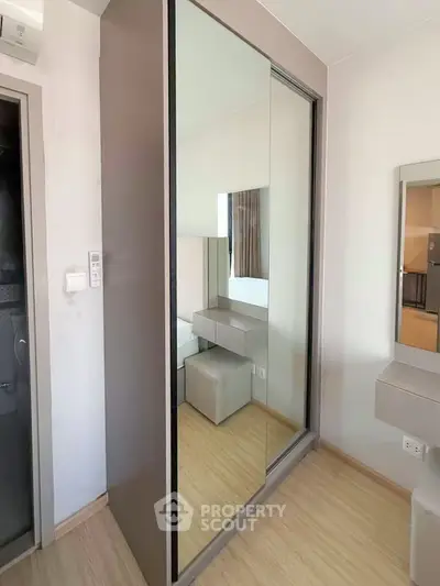 Modern bedroom with mirrored wardrobe and sleek wooden flooring