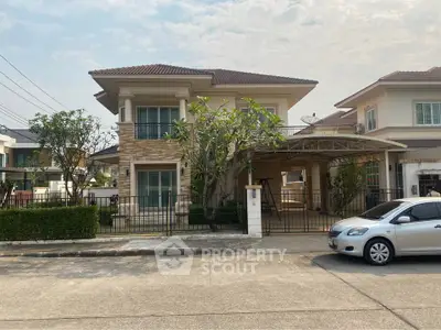 Charming two-story suburban house with lush greenery and spacious driveway in a serene neighborhood.