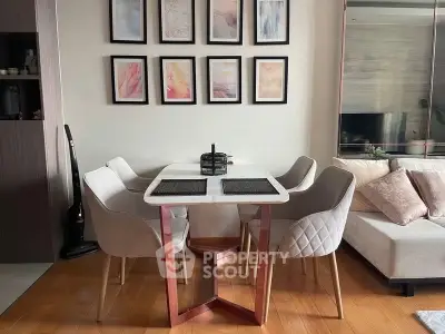 Modern dining area with stylish chairs and wall art in a cozy living room setting.