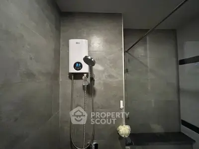 Modern bathroom with sleek shower and water heater in stylish gray tiles.