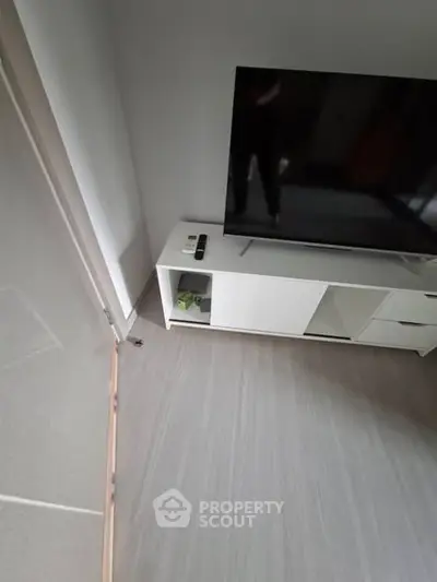 Modern living room with sleek TV stand and large flat-screen TV, perfect for entertainment.