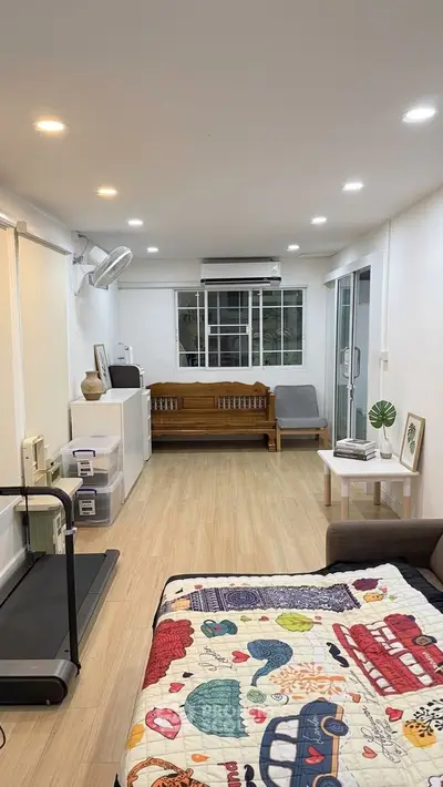 Spacious living room with treadmill and cozy decor in modern apartment