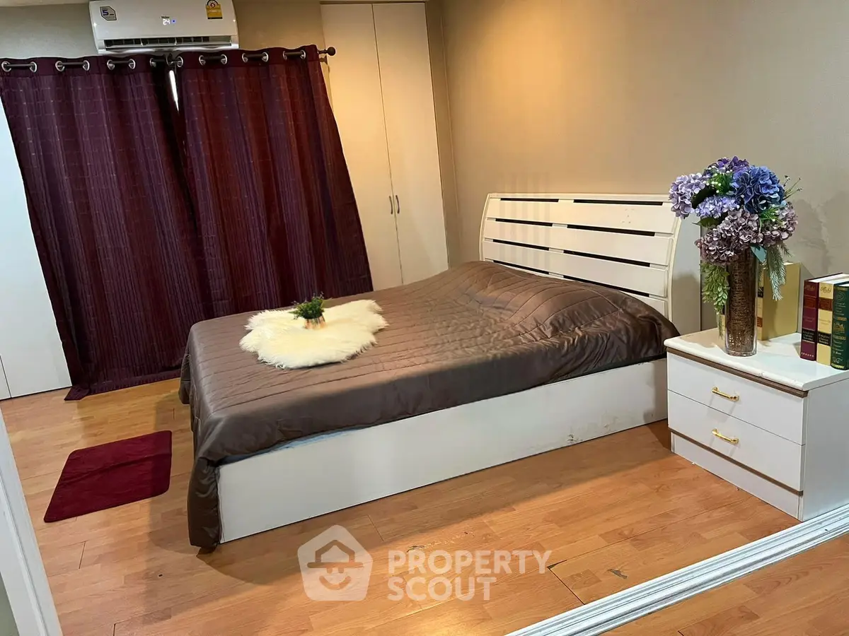 Cozy bedroom with elegant decor and wooden flooring, featuring a stylish bed and chic curtains.