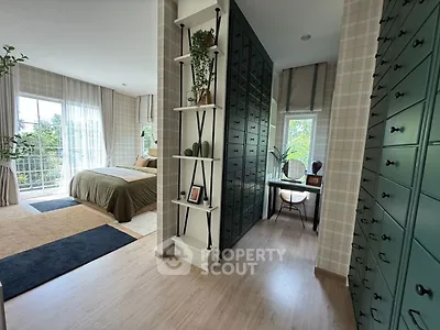 Spacious bedroom with elegant decor and natural light, featuring a cozy study nook and ample storage.