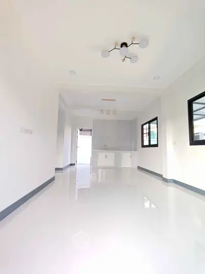 Spacious modern kitchen with sleek white cabinetry and minimalist lighting.