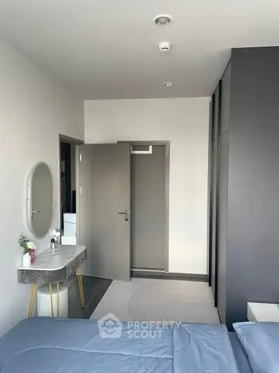 Modern bedroom with sleek gray accents and stylish vanity in a contemporary apartment.