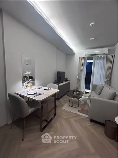 Modern living room with dining area and balcony access in stylish apartment.