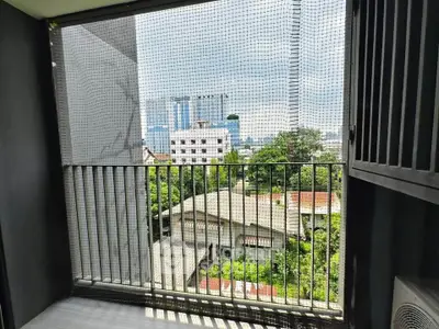 Spacious balcony with city view and safety netting, perfect for urban living.