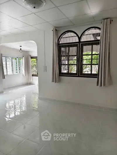 Spacious living room with arched windows and bright natural light