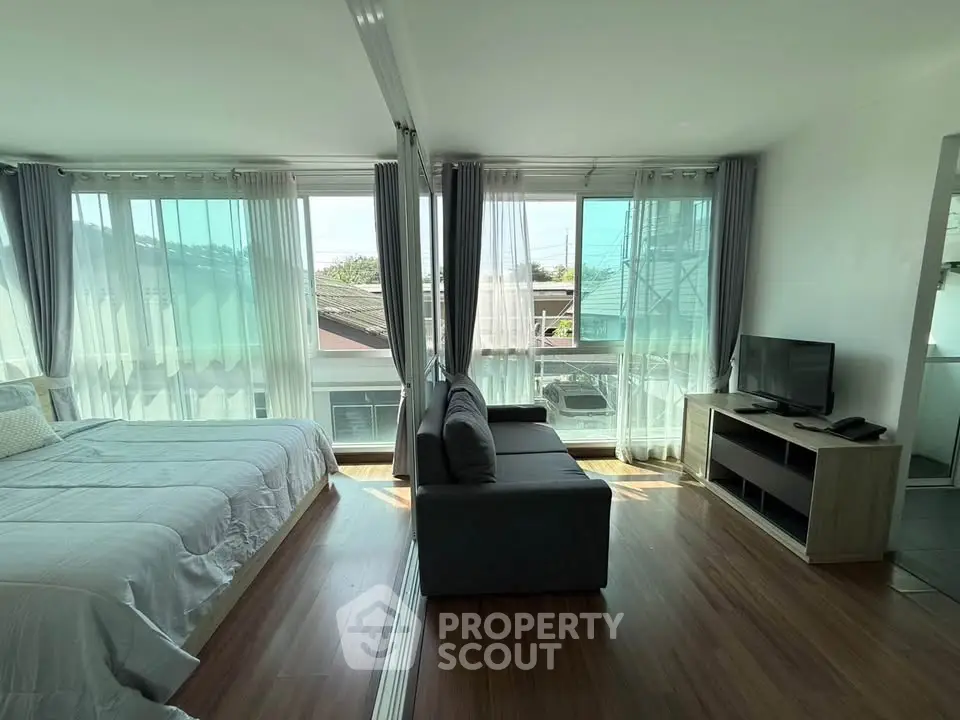 Modern studio apartment with large windows and natural light