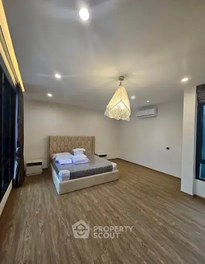 Spacious bedroom with modern design and large windows in a luxury apartment.