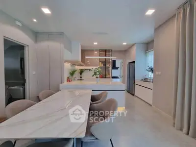Modern kitchen with sleek design, marble dining table, and open layout in a stylish apartment.