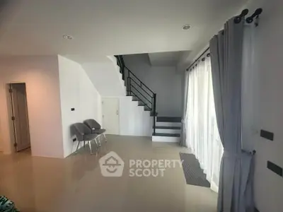 Spacious modern living room with staircase and large windows