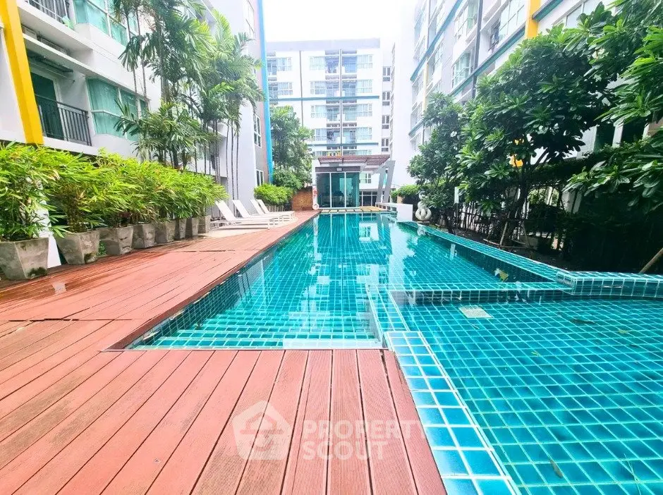 Luxurious condominium pool area with modern design and lush greenery