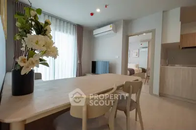 Modern open-plan living room with dining area and kitchen in stylish apartment.