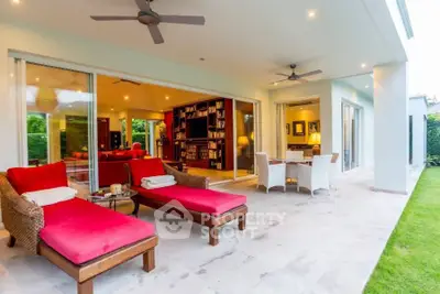 Luxurious patio with red loungers and open view to elegant living room