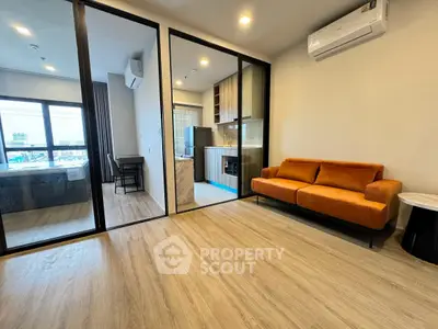 Modern apartment interior with open layout, featuring a cozy living room and stylish kitchen.