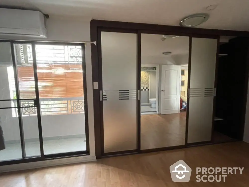 Spacious and well-lit corner unit with large sliding doors leading to a sunny balcony, featuring a seamless indoor-outdoor flow.