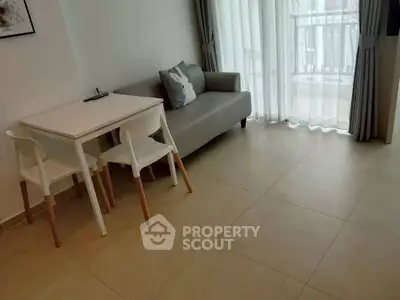 Modern living room with minimalist decor and natural light, featuring a cozy sofa and dining area.