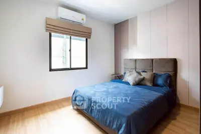 Cozy bedroom with modern decor and natural light, featuring a comfortable bed and stylish window treatment.