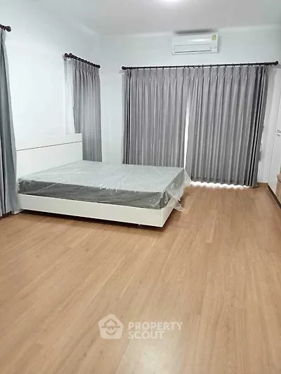Spacious bedroom with modern design and large windows for natural light.