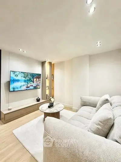 Modern living room with cozy sofa and wall-mounted TV, perfect for relaxation.