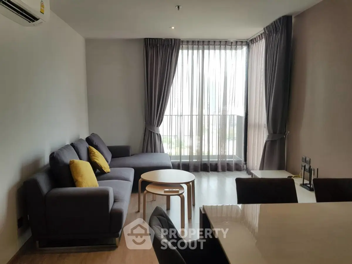 Modern living room with large windows and stylish furniture in a cozy apartment.