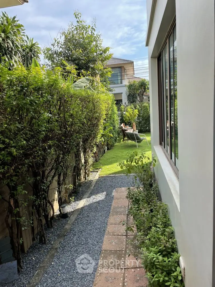 Charming garden pathway leading to a lush backyard in a suburban home.