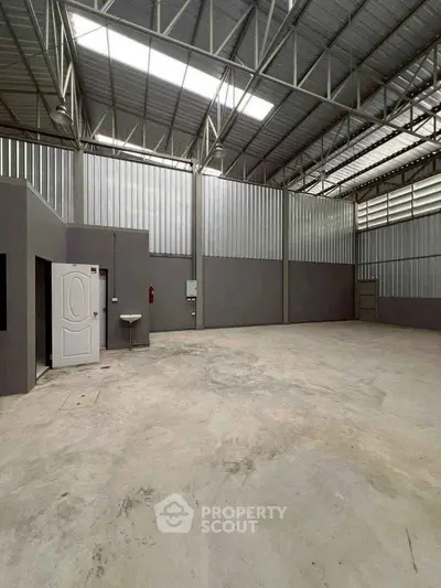 Spacious industrial warehouse with high ceilings and ample natural light, perfect for storage or manufacturing.