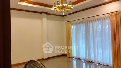 Elegant living room with chandelier and large windows with curtains