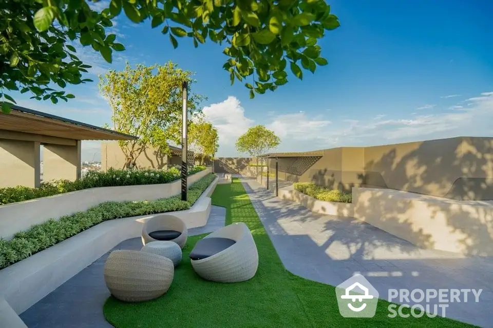 Stunning rooftop garden with modern seating and lush greenery under a clear blue sky.