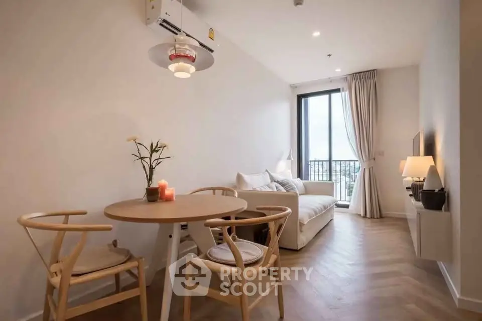 Modern living room with elegant decor and natural light, featuring a cozy dining area and stylish furniture.