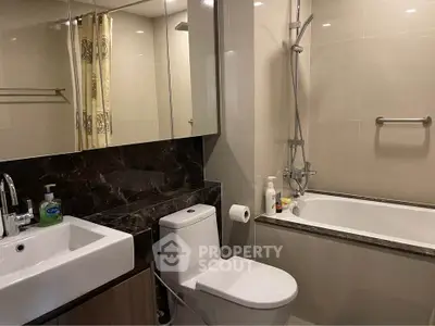 Modern bathroom with sleek fixtures and a bathtub in a contemporary apartment.
